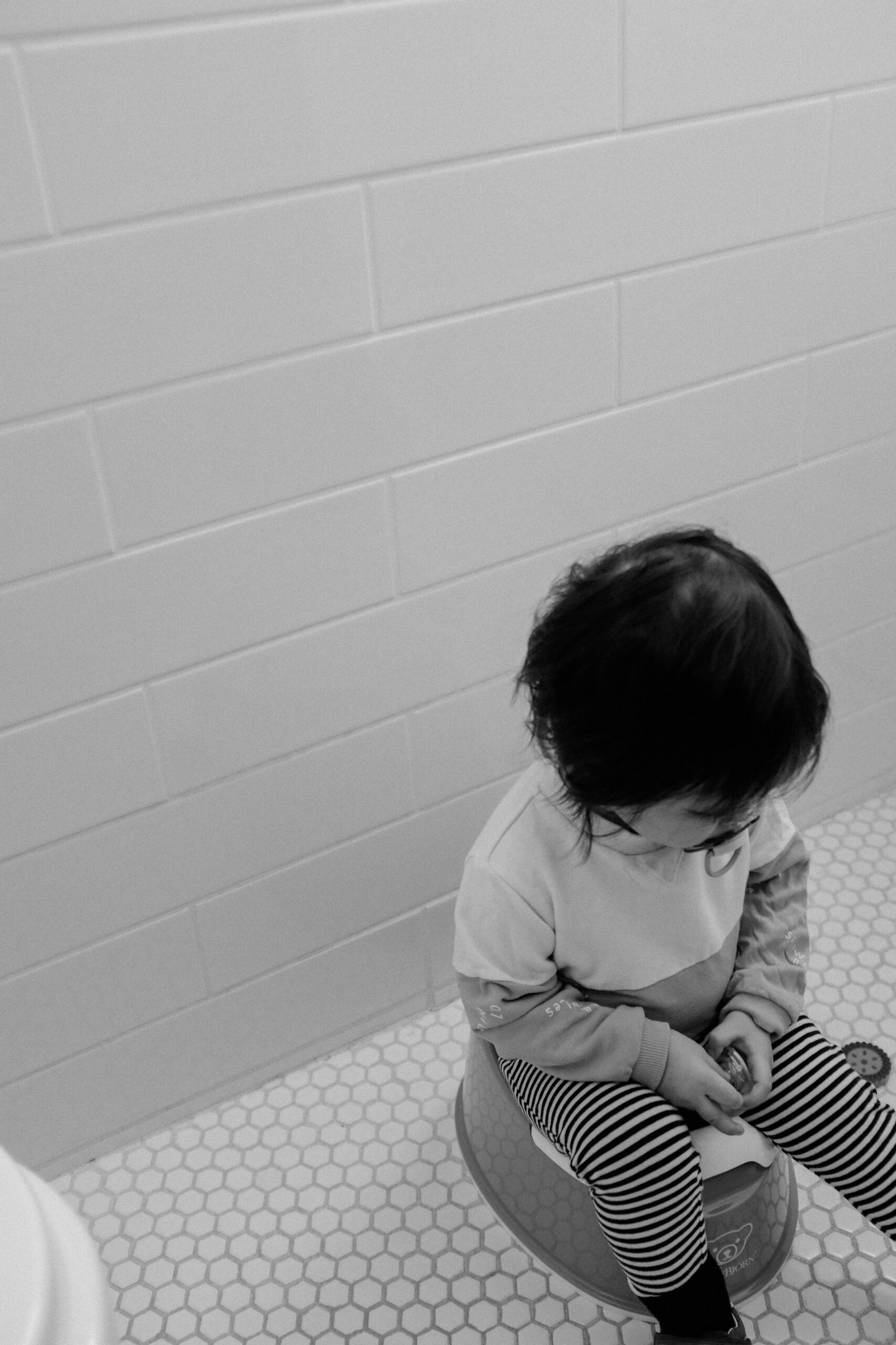 How to Potty train a Boy. grayscale photo of child in white long sleeve shirt sitting on floor